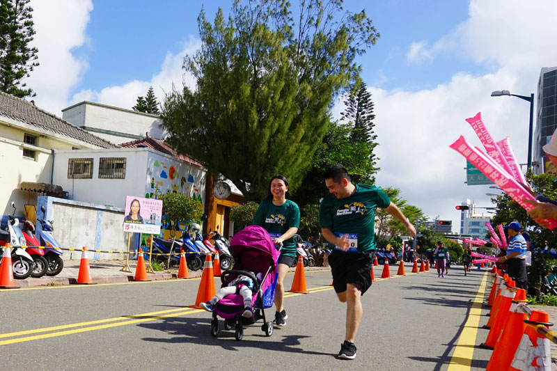 유모차의 아이와 함께 5km를 달린 아이 엄마가 결승선을 향해 달려오고 있다