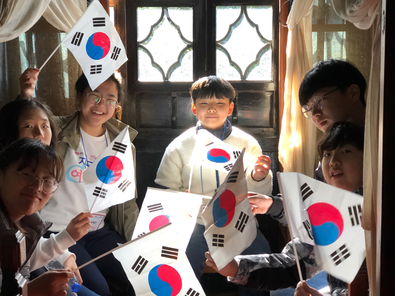 김구 피난처에서 태극기를 흔들며 웃음짓고 있는 아이들