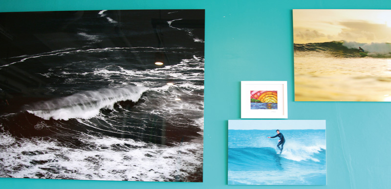 서프오션 벽에 걸려 있는 사진들. 여름, 죽도해변의 파도는 사진처럼 거세지 않다