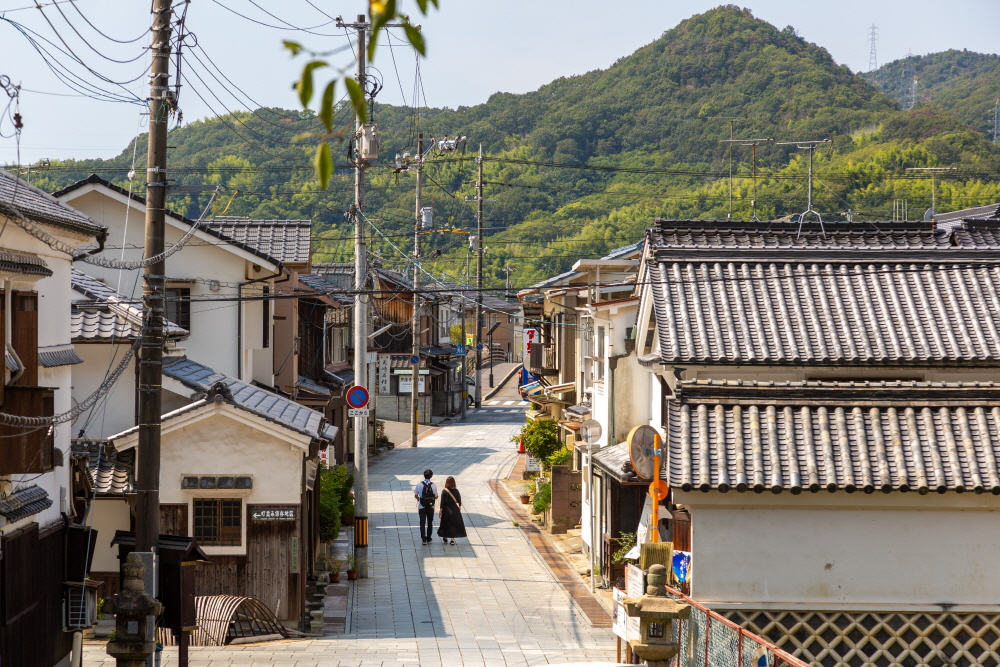여행자들이 전통가옥이 늘어선 거리를 산책하고 있다